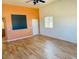Living room with laminate wood flooring, an accent wall, and door access at 51631 W Turney Ln, Maricopa, AZ 85139