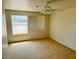 Spacious bedroom featuring a large window and ceiling fan at 51631 W Turney Ln, Maricopa, AZ 85139