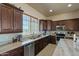 Well-equipped kitchen featuring granite countertops and dark wood cabinets at 32120 N 167Th Ave, Surprise, AZ 85387