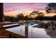 Evening view of the pool with wine glasses on the counter at 10721 E La Junta Rd, Scottsdale, AZ 85255