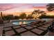 Scenic pool at dusk with fire features and lounge chairs at 10721 E La Junta Rd, Scottsdale, AZ 85255
