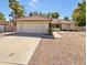 Single-story home with a two-car garage and desert landscaping at 4801 E Nisbet Rd, Scottsdale, AZ 85254