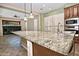 Kitchen boasts granite countertops, stainless steel appliances, and custom wood cabinetry at 13055 W Eagle Talon Trl, Peoria, AZ 85383