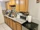 Galley kitchen with wood cabinets, granite countertops, microwave, and ice maker at 5418 W Belleview St, Phoenix, AZ 85043