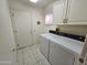 Laundry room with white cabinets, washer, and dryer at 15406 W Sky Hawk Dr, Sun City West, AZ 85375