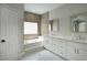 Elegant bathroom with double vanity, soaking tub, and tile flooring at 3981 N 155Th Ave, Goodyear, AZ 85395
