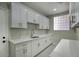 Bright laundry room with white cabinets, quartz countertops, and a block window at 3981 N 155Th Ave, Goodyear, AZ 85395