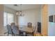 Dining area with a wood table, chandelier, and gray chairs at 913 S 115Th Dr, Avondale, AZ 85323