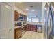 Well-equipped kitchen featuring dark wood cabinets, stainless steel appliances, and tile flooring at 913 S 115Th Dr, Avondale, AZ 85323