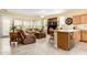 Open concept kitchen and living room with tile floors and a breakfast bar at 26723 N 127Th Dr, Peoria, AZ 85383
