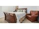 Cozy bedroom with a sleigh bed and a comfortable armchair at 26723 N 127Th Dr, Peoria, AZ 85383