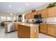 Open kitchen with island, stainless steel appliances, and wood cabinets at 26723 N 127Th Dr, Peoria, AZ 85383