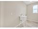 Laundry room with utility sink and light wood-look floors at 13036 N 20Th St, Phoenix, AZ 85022