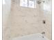 Shower with marble-look tile and built-in shelving at 13036 N 20Th St, Phoenix, AZ 85022
