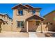Two-story stucco home with a terracotta tile roof, shutters, and a welcoming front porch at 824 E Agua Fria Ln, Avondale, AZ 85323