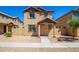 Two-story stucco home with a terracotta tile roof, shutters, and a welcoming front porch at 824 E Agua Fria Ln, Avondale, AZ 85323