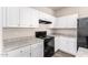 White kitchen cabinets and black appliances at 847 E Agua Fria Ln, Avondale, AZ 85323