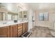 Bathroom with double sinks, large mirror, and tiled floor at 17797 W Carmen Dr, Surprise, AZ 85388