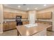 Eat-in kitchen with wood cabinets, an island, and tile flooring at 17797 W Carmen Dr, Surprise, AZ 85388