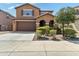 Two-story house with brown exterior, attached garage, and landscaping at 21243 W Coronado Rd, Buckeye, AZ 85396