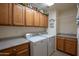 Laundry room with wood cabinets, washer, and dryer at 3285 N 159Th Ave, Goodyear, AZ 85395