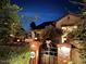Night view of the home's exterior, featuring a gated entryway and lighting at 15576 W Coral Pointe Dr, Surprise, AZ 85374
