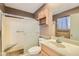 Bathroom with shower, toilet, vanity, and wood cabinet at 10619 W Clair Dr, Sun City, AZ 85351