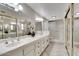 Double vanity bathroom with a large mirror and shower at 19434 N 130Th Ave, Sun City West, AZ 85375