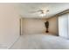 Bright and spacious living room with carpeted floors and ceiling fan at 19434 N 130Th Ave, Sun City West, AZ 85375