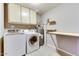 Laundry room with washer, dryer, and overhead cabinets at 19434 N 130Th Ave, Sun City West, AZ 85375