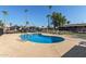 Kidney-shaped community pool with lounge chairs and surrounding patio at 501 E Ray Rd # 211, Chandler, AZ 85225