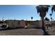 Demolition site with partial walls and boarded windows, located on a gravel lot with palm trees at 5416 E Akron St, Mesa, AZ 85205