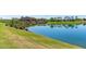 Serene lakefront view with lush landscaping and community clubhouse at 17540 W Glenhaven Dr, Goodyear, AZ 85338