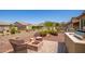 Relaxing patio with fire pit and seating area, next to a built-in grill at 17540 W Glenhaven Dr, Goodyear, AZ 85338
