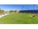 Community lawn games area with cornhole and a scenic pond view at 17540 W Glenhaven Dr, Goodyear, AZ 85338