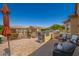 Outdoor kitchen and patio area with seating, fire pit, and umbrella at 17540 W Glenhaven Dr, Goodyear, AZ 85338