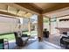 Relaxing covered patio with wicker furniture and view of a grassy backyard at 18535 W Udall Dr, Surprise, AZ 85374