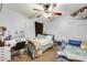 Cozy bedroom with twin beds, desk, and ceiling fan at 18535 W Udall Dr, Surprise, AZ 85374