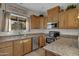 Kitchen with wood cabinets, granite countertops, and stainless steel appliances at 21151 E Mewes Rd, Queen Creek, AZ 85142