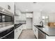Modern kitchen with white cabinets, stainless steel appliances, and dark countertops at 9239 E Spiral Ave, Mesa, AZ 85212