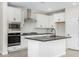 Modern kitchen with white cabinets, stainless steel appliances, and dark countertops at 9239 E Spiral Ave, Mesa, AZ 85212