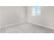 Simple carpeted bedroom with large window and neutral walls at 9239 E Spiral Ave, Mesa, AZ 85212