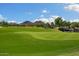 Picturesque golf course view with lush greens and mountain backdrop at 26562 W Vista North Dr, Buckeye, AZ 85396
