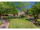 Green backyard with mature trees and partial house view at 1201 W Washington Ave, Gilbert, AZ 85233