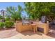 Built-in outdoor kitchen with grill and bar seating at 1201 W Washington Ave, Gilbert, AZ 85233