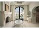 Large bathroom with soaking tub, fireplace, and French doors leading to the backyard at 10947 E Wingspan Way, Scottsdale, AZ 85255