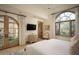 Primary bedroom with French doors opening to a private patio and a large window at 10947 E Wingspan Way, Scottsdale, AZ 85255