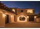 Night view of home's exterior with grand entry and garage at 10947 E Wingspan Way, Scottsdale, AZ 85255