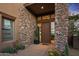 Inviting entryway with stone accents and a modern wood door at 39115 N 99Th Pl, Scottsdale, AZ 85262