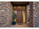 Stone and wood exterior entryway with a modern door at 39115 N 99Th Pl, Scottsdale, AZ 85262